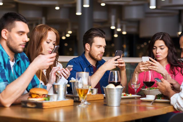 レストランでスマートホンを見る人たち